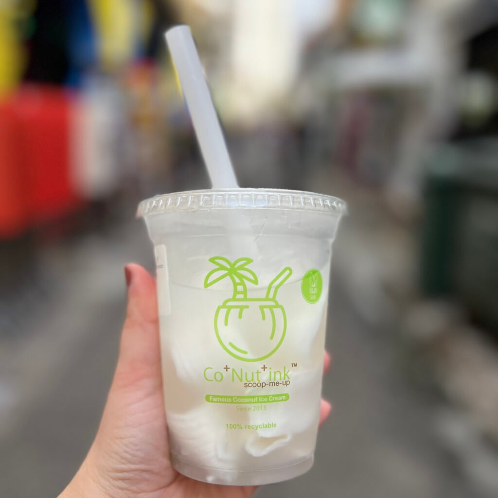 Cup of coconut water with coconut shavings inside